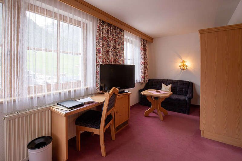 Desk and couch in the Comfort Double Room at Hotel Persura